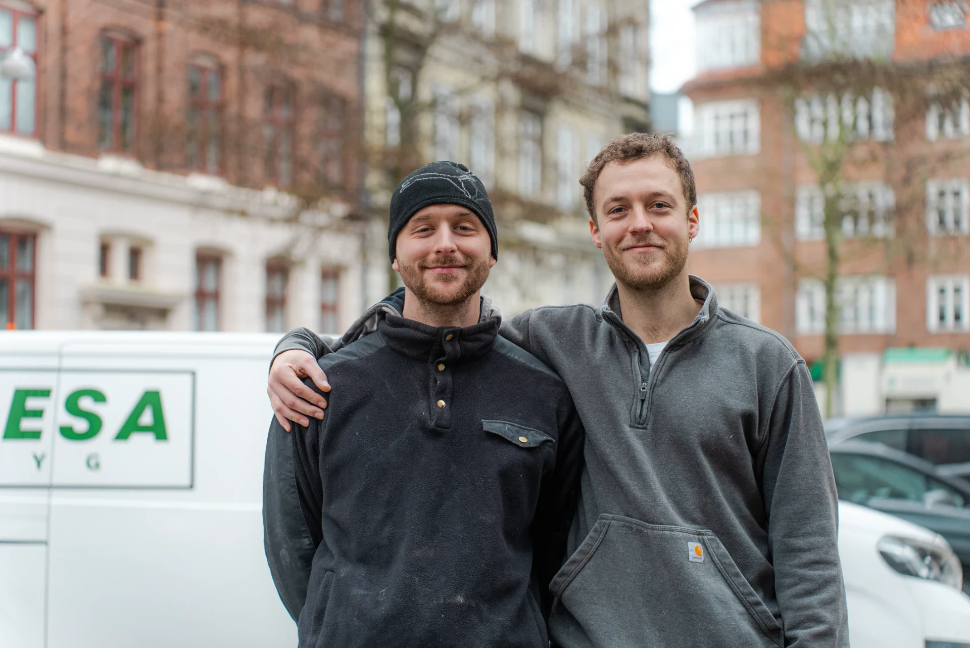 To mænd står foran byggebil, klar til at starte byggeprojekt.